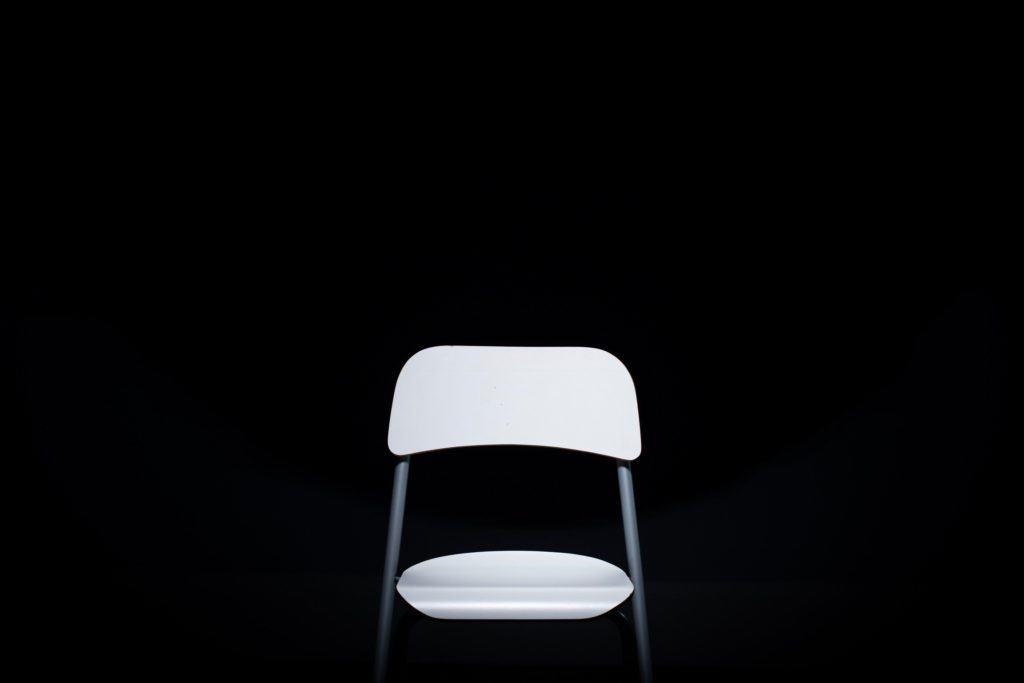 White metal chair on black background